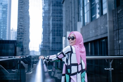 Standing on the street of the woman wearing a pink scarf
